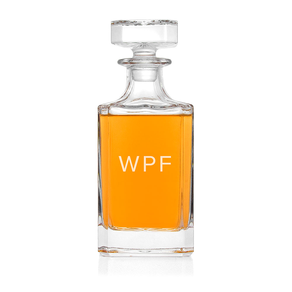 Clear glass decanter with orange liquid and 'WPF' branding on a white background