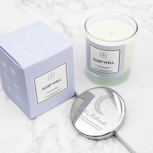 Candle labeled 'Sleep Well' with packaging and a mirror on a marble surface