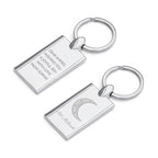 Two silver keychains with engraved text on a white background