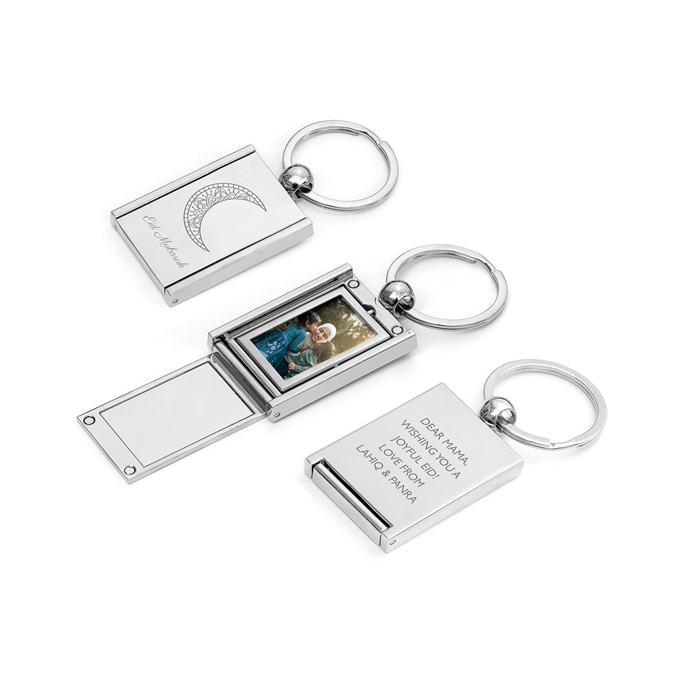 Silver keychain with photo display and engraving on a white background