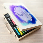 Set of colored pencils in a wooden case with a watercolor design on the lid.