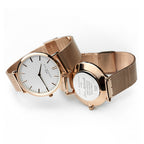 Two gold mesh watches on a white background
