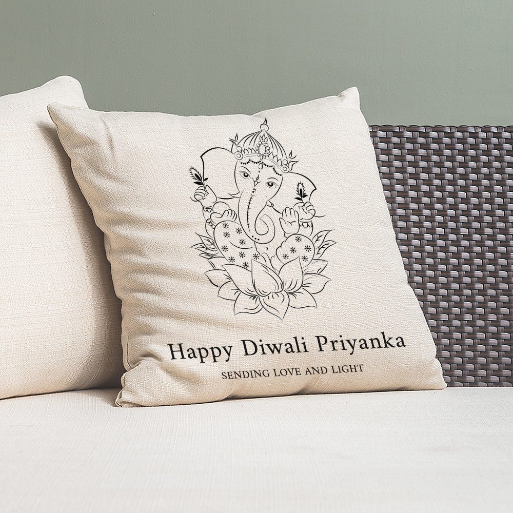 Decorative pillow with Ganesha design and text on a couch