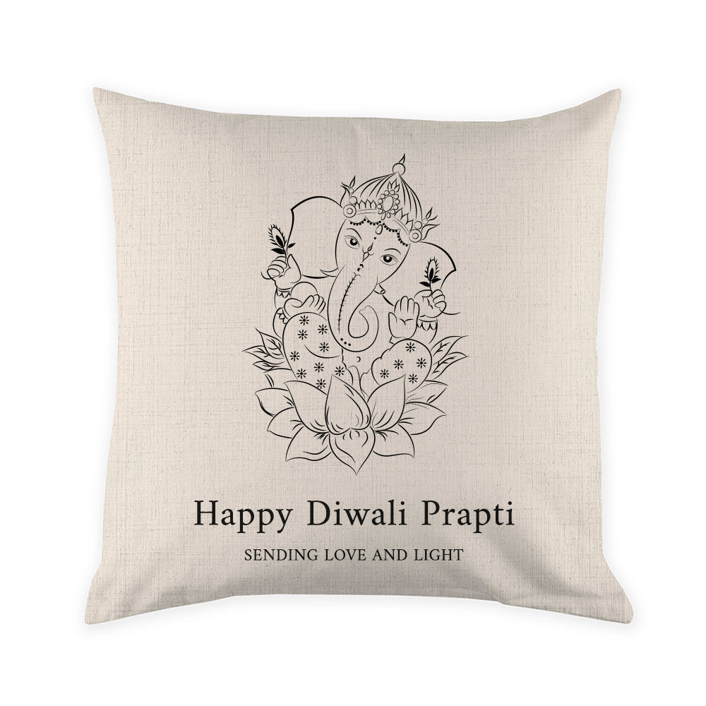 Decorative pillow with Ganesha design and 'Happy Diwali Prapti' text on a beige background