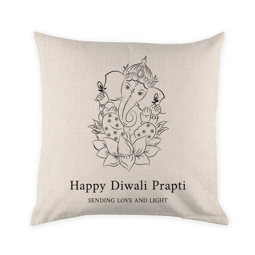 Decorative pillow with Ganesha design and 'Happy Diwali Prapti' text on a beige background