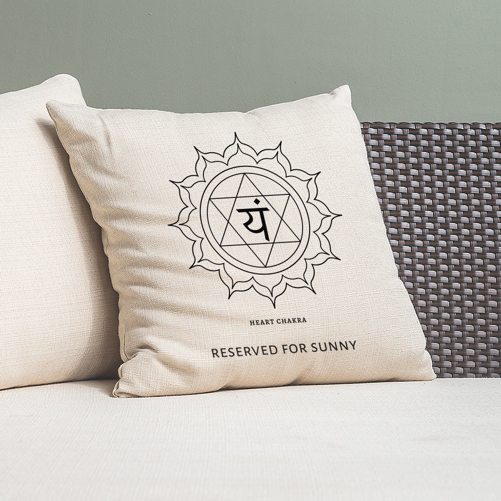 Beige pillow with a symbol and text on a gray couch