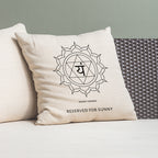 Beige pillow with a symbol and text on a gray couch