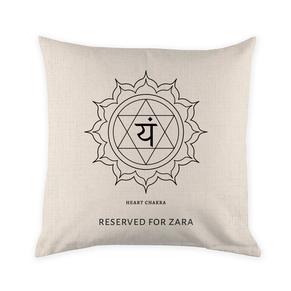 Beige pillow with black symbol and text on a white background