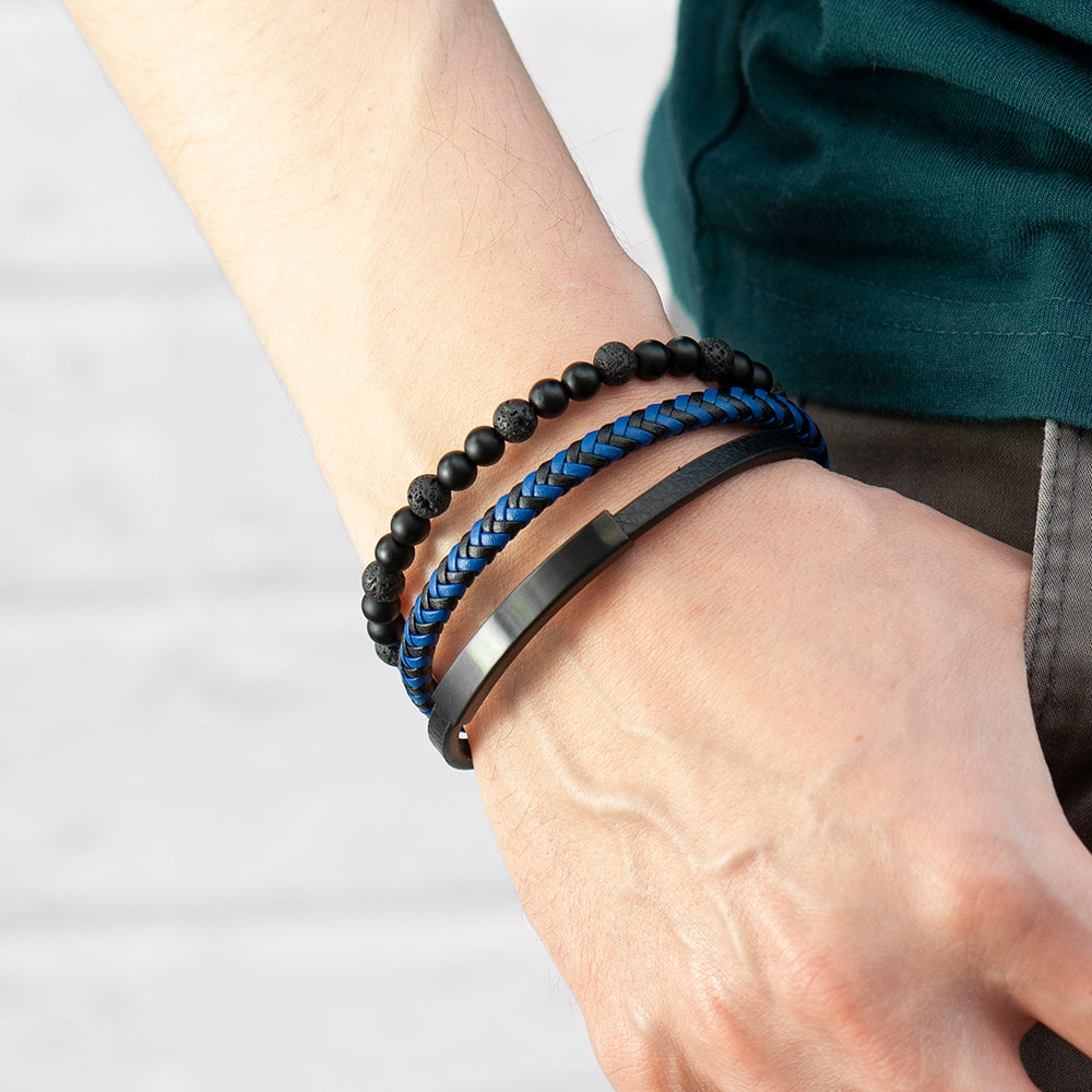 Close-up of a wrist wearing three bracelets on a plain background