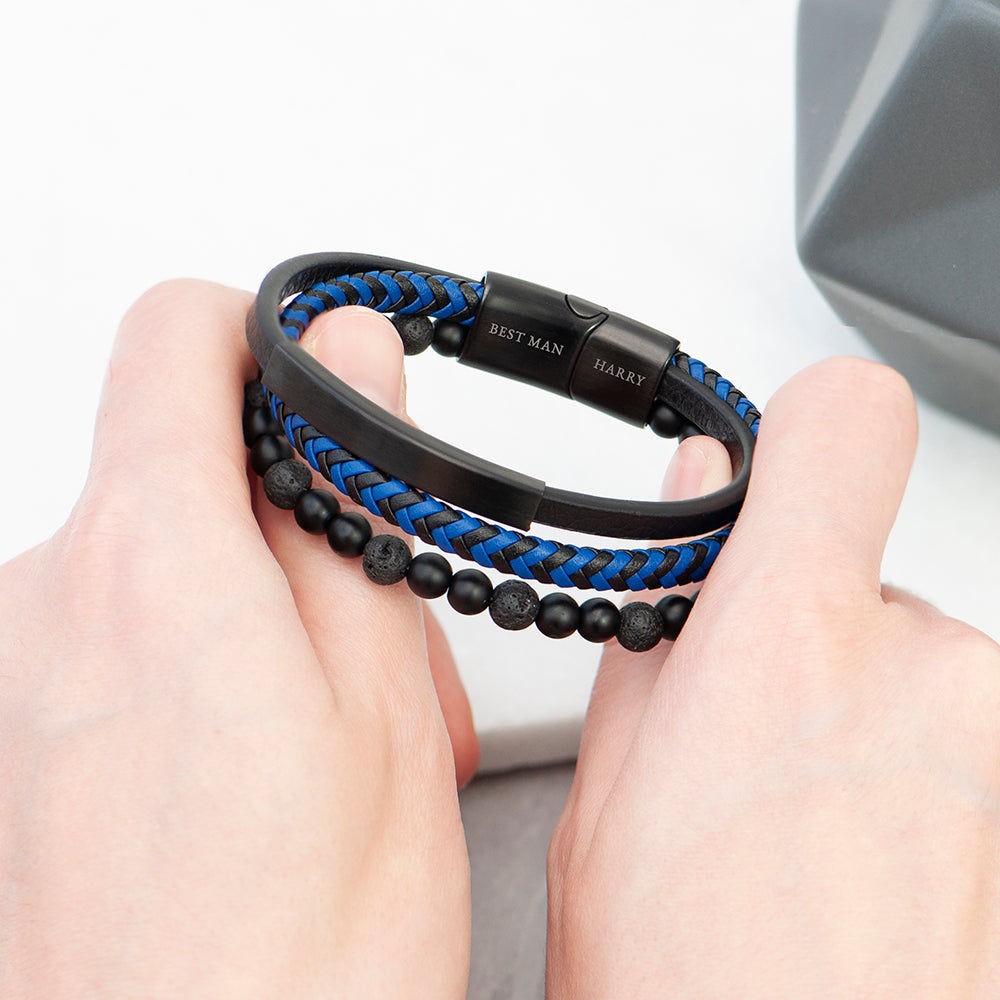Two hands holding a black and blue braided bracelet with beads.