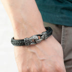 Black leather bracelet with silver intricate design on a wrist