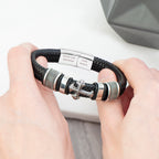 Bracelet with decorative elements held by hands on a neutral background