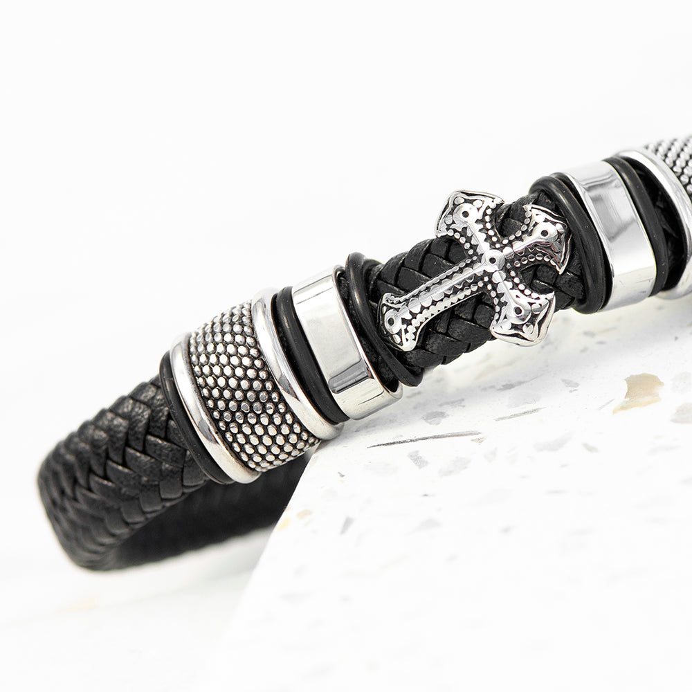 Black braided leather bracelet with silver metal accents on a white background
