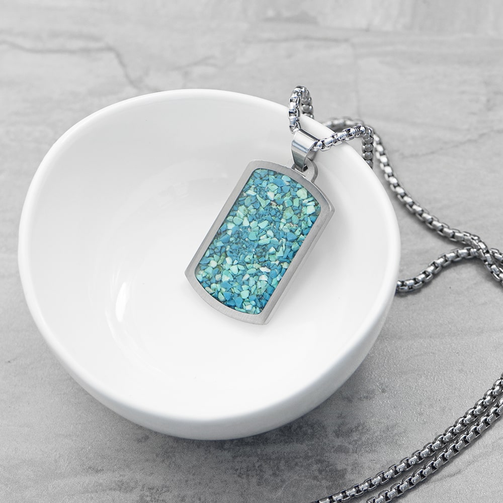 Necklace with a blue pendant on a white dish