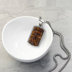 Necklace with a pendant on a white dish against a gray background