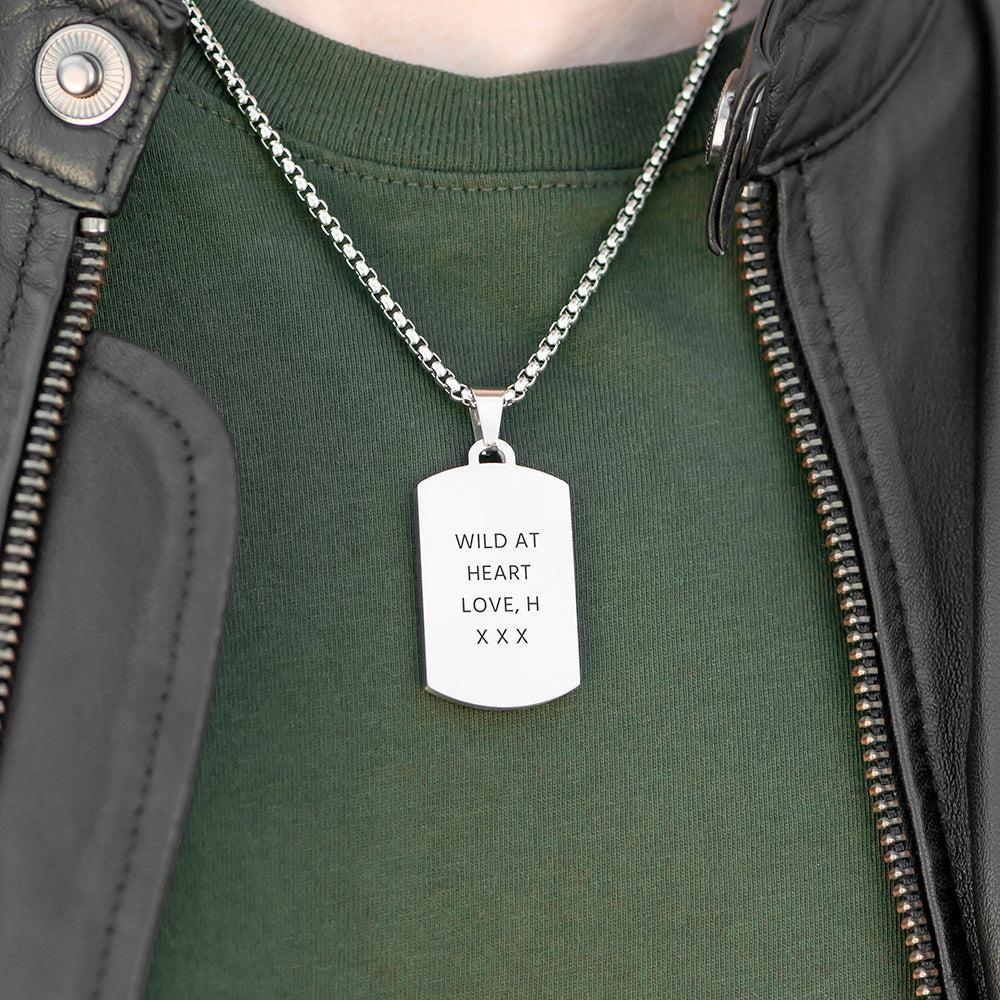 Person wearing a green shirt with a silver necklace featuring a dog tag.