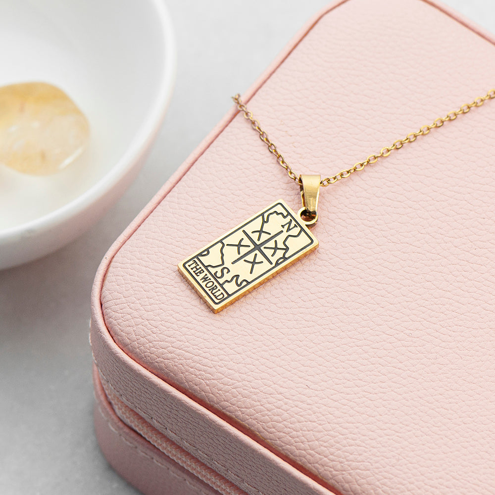 Gold necklace with a pendant on a pink jewelry box