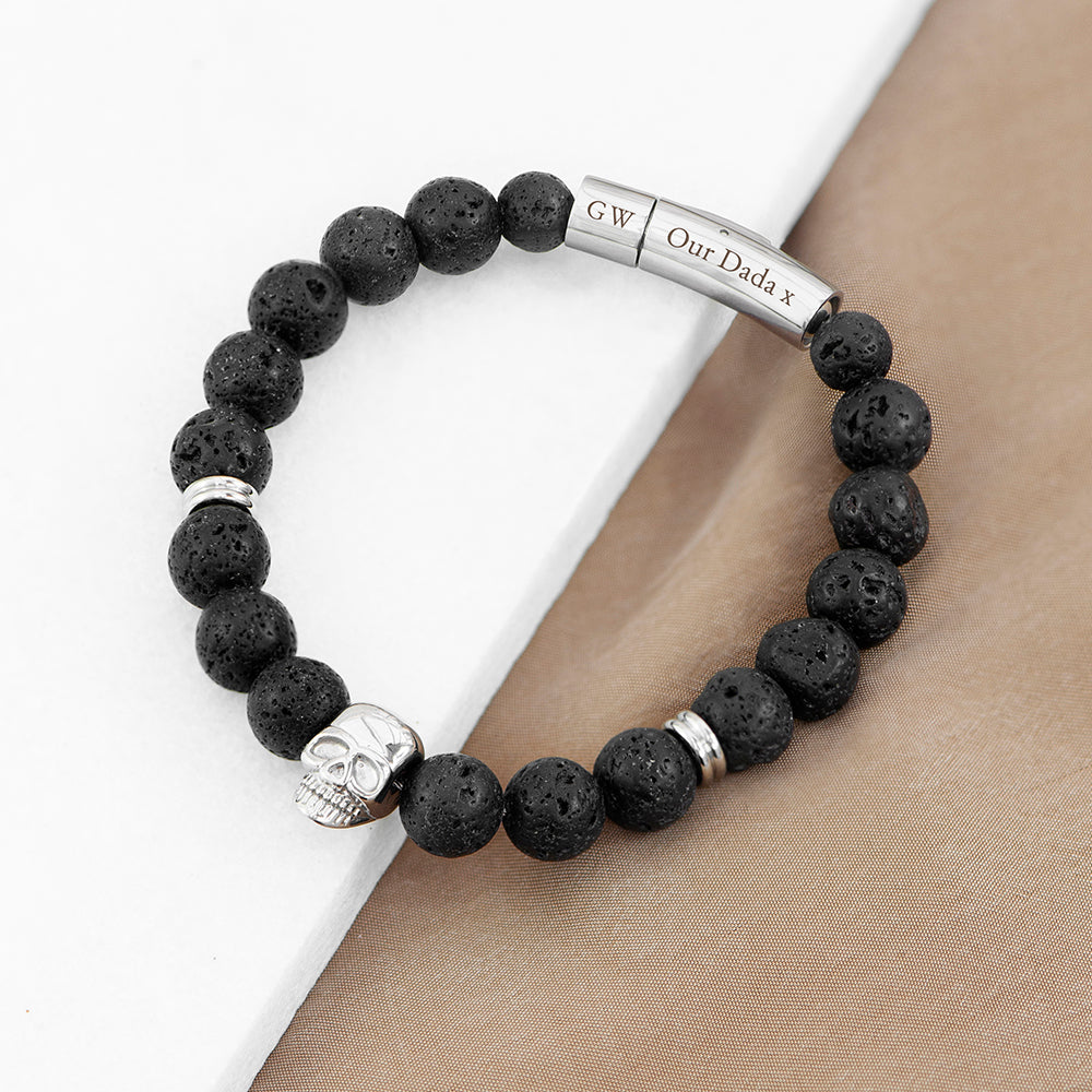 Black beaded bracelet with skull charm and engraved metal tag on wrist
