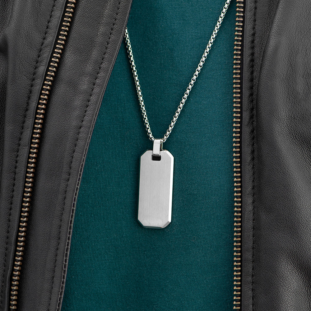 Silver dog tag necklace on a green shirt with a black leather jacket