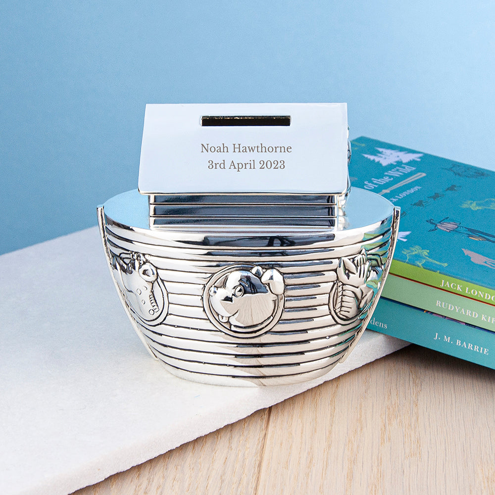 Silver baby bowl with engraved design on a light blue background
