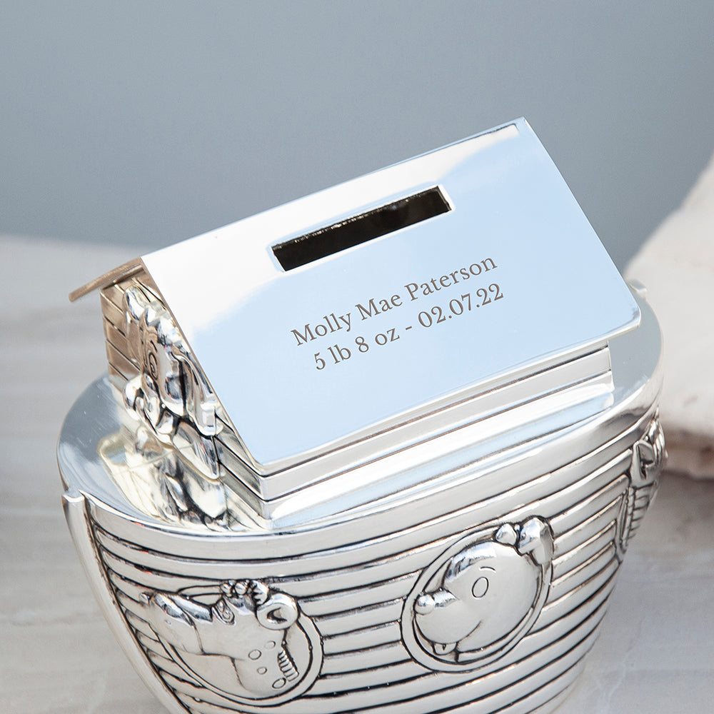 Silver baby book with engraved text on a gray background