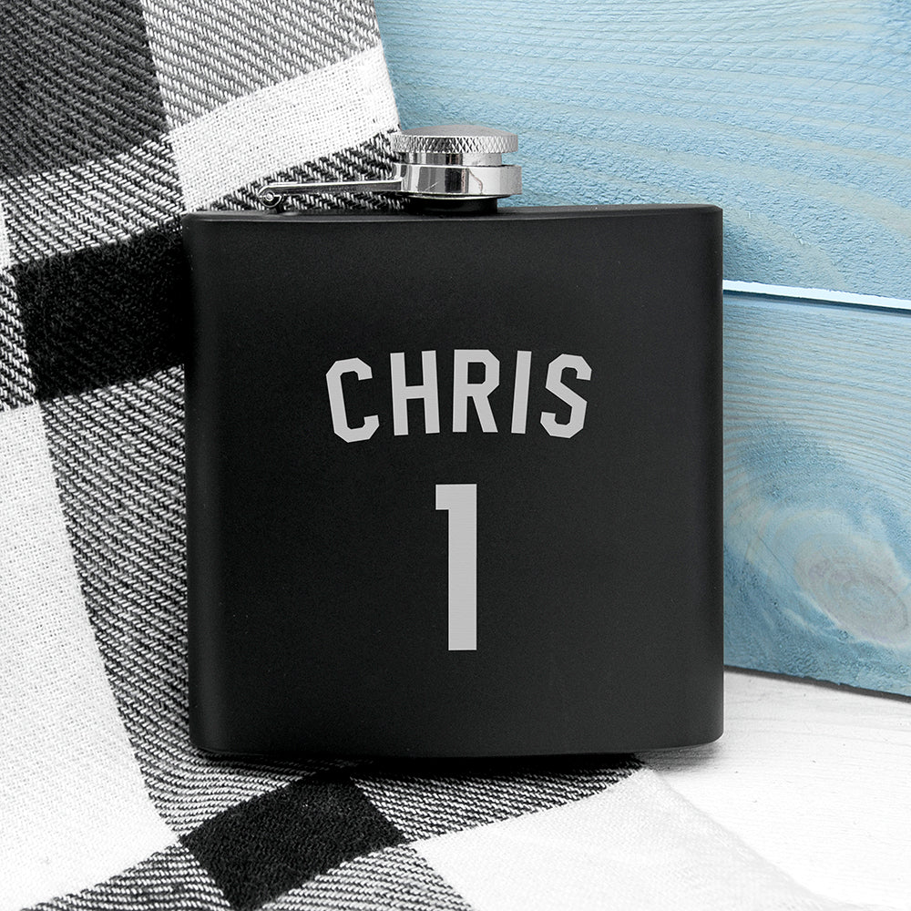 Black flask with 'CHRIS' and number '1' on a checkered fabric background
