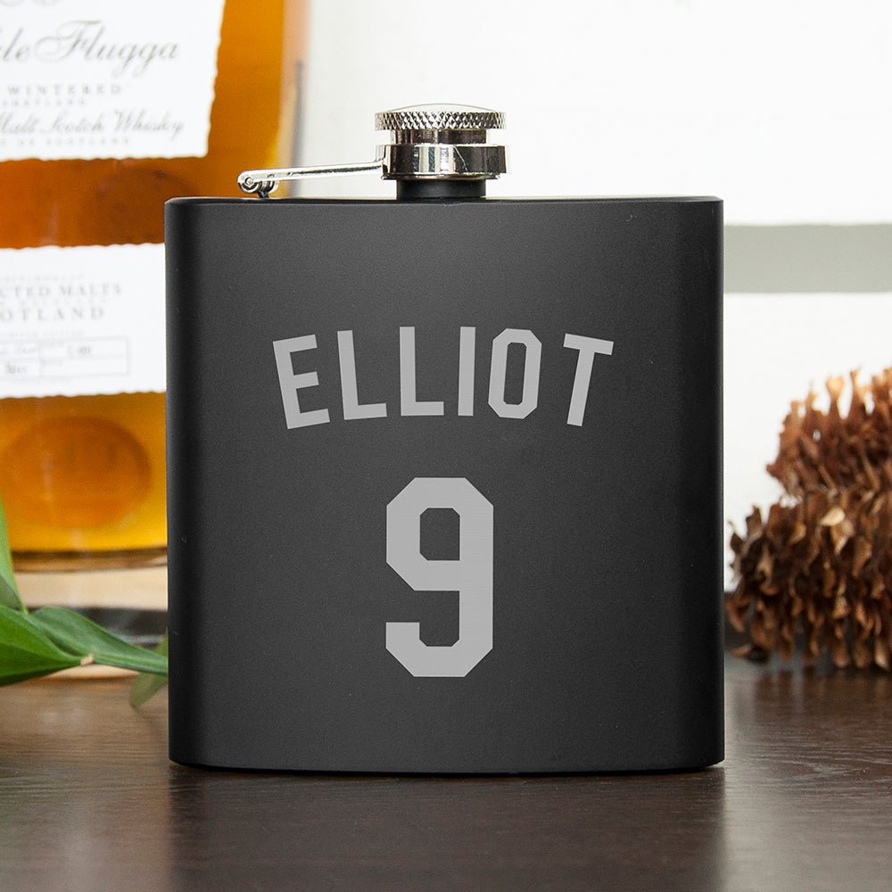 Black flask with 'ELLiot 9' engraving on a wooden surface