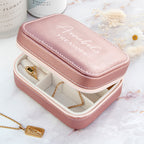 Pink jewelry box with 'Annamarie's Treasure' text, containing a necklace and pendant on a white surface.