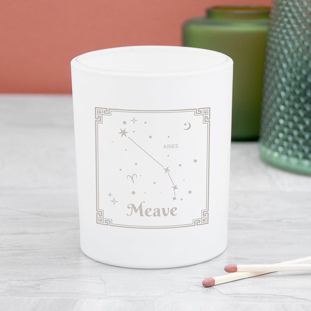 White candle with star constellation design and 'Daniella' text on a light surface.