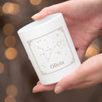 Hand holding a white Zara product with star constellation design against a blurred background