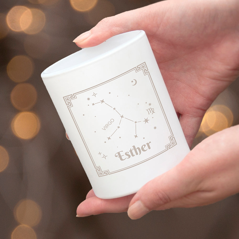 Hand holding a white Zara product with star constellation design against a blurred background