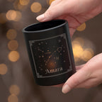 Black mug with star design and 'Olivia' text held by a hand against a blurred background
