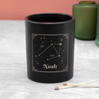 Black candle with Libra constellation design and 'Noah' text on a white surface.