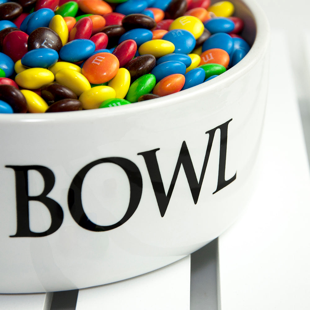 White bowl filled with colorful M&M candies on a white background