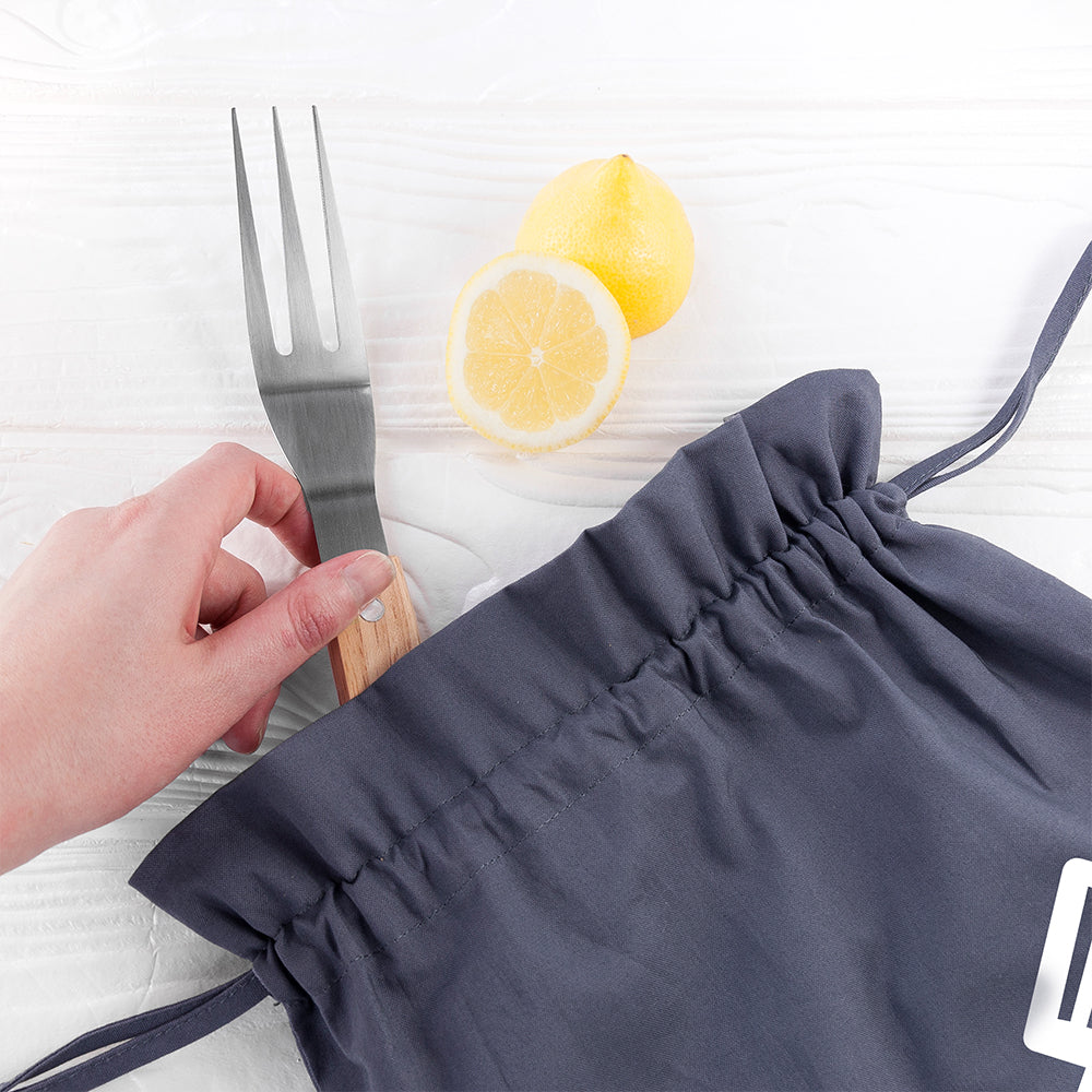 Navy drawstring bag with a hand holding a fork, sliced lemon, and whole lemon on a white background.