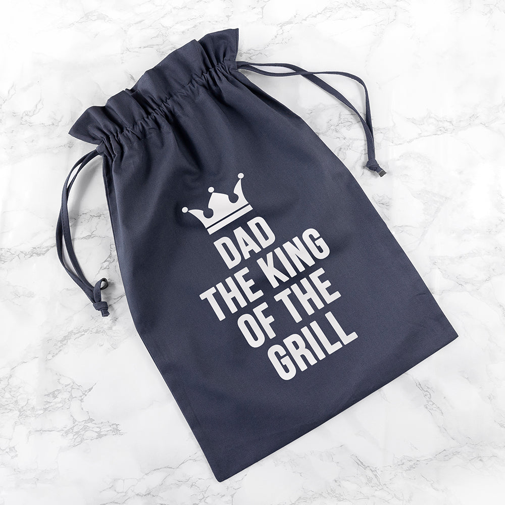 Navy drawstring bag with 'Dad, The King of The Grill' text on a marble background