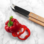 Red pepper sliced in half with a knife on a marble surface