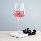 Wine glass with pink wine and personalized text on a marble coaster with grapes