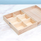 Wooden jewelry box with compartments on a marble surface
