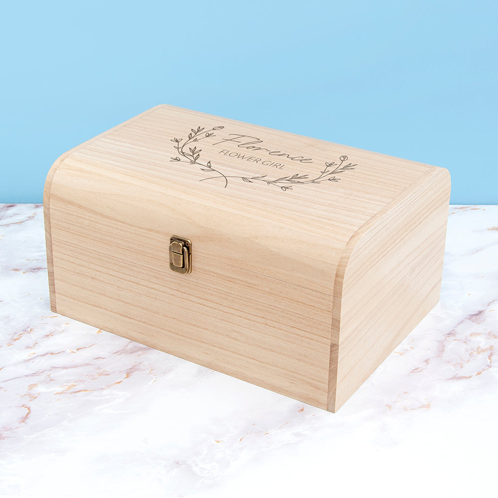 Wooden box with engraved text on a marble surface with a light blue background