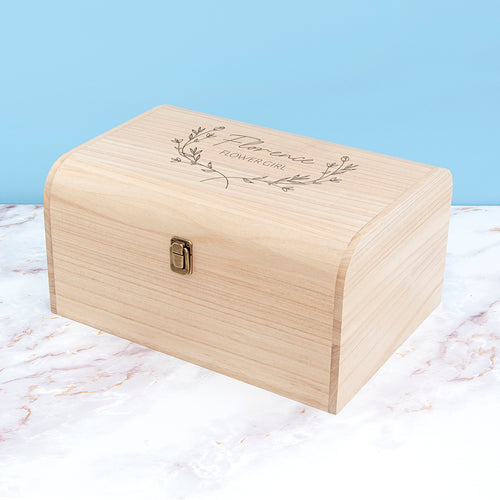Wooden box with engraved text on a marble surface with a light blue background
