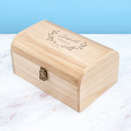 Wooden box with engraved text on a marble surface
