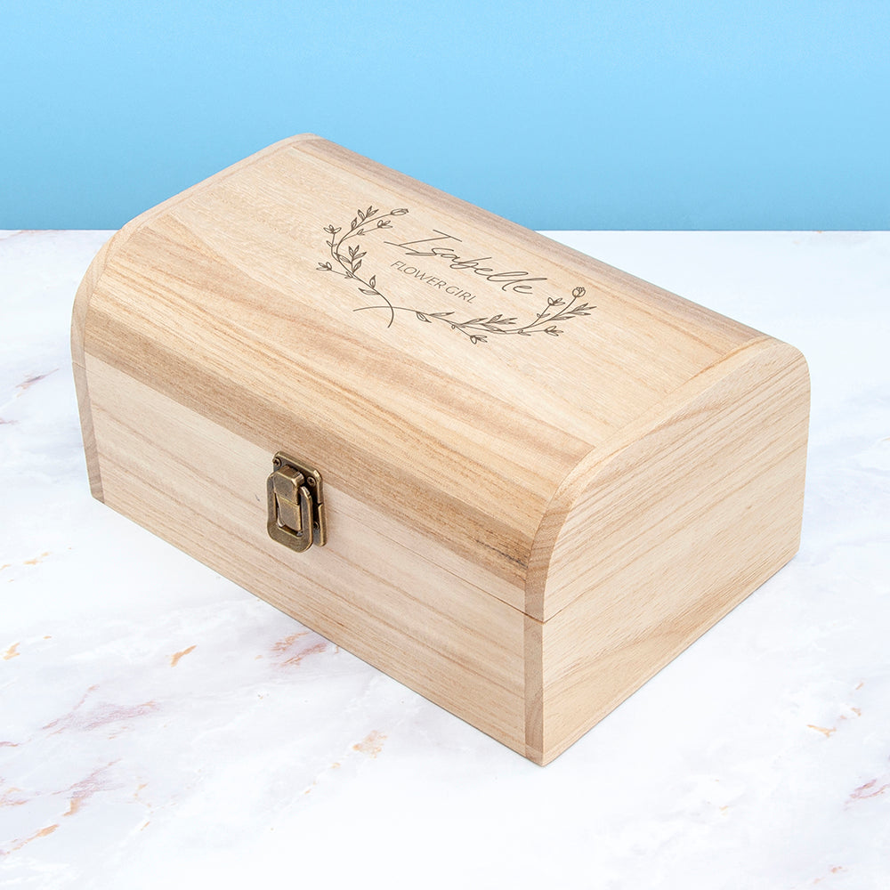 Wooden box with engraved text on a marble surface