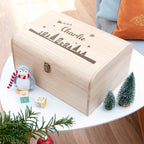 Wooden box with 'Charlie' engraving on a table with Christmas decorations