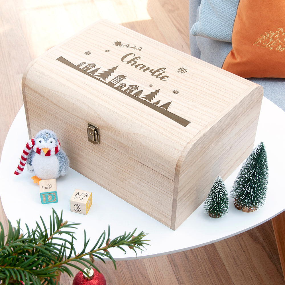 Wooden box with 'Charlie' engraving on a table with Christmas decorations