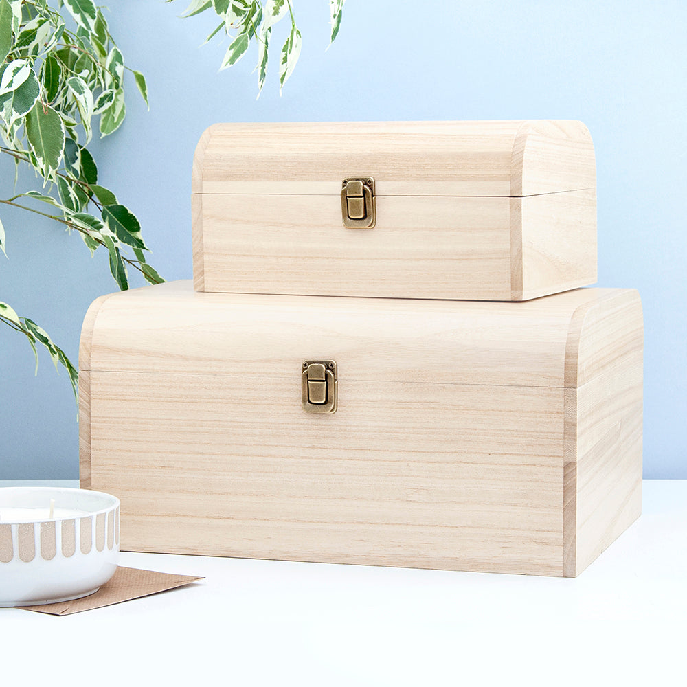 Two beige storage boxes with gold latches on a light blue background