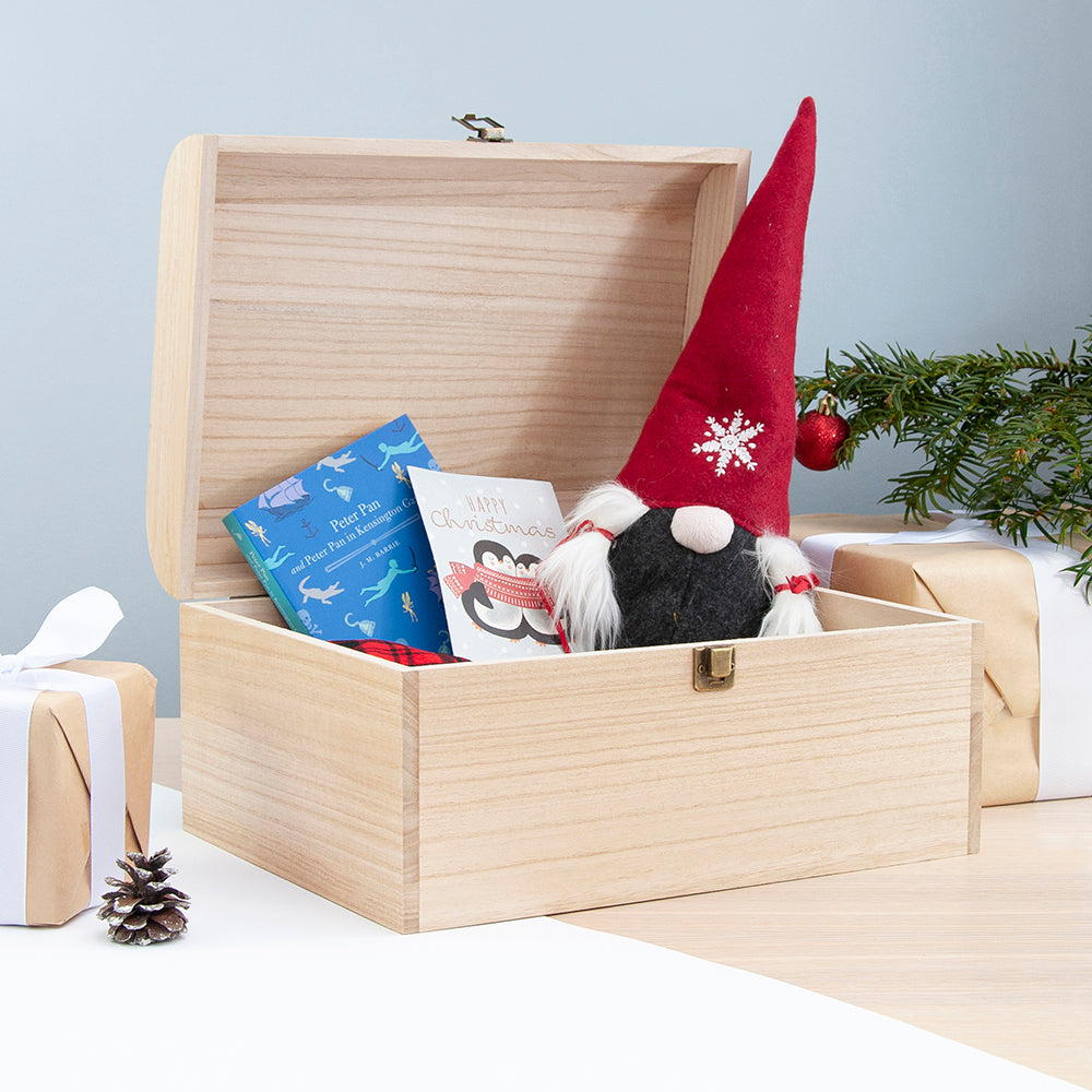 Wooden box with a gnome, books, and a gift on a light blue background