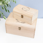 Two wooden boxes with engraved designs on a light background