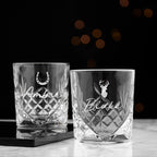 Two crystal glasses with engraved names on a dark background