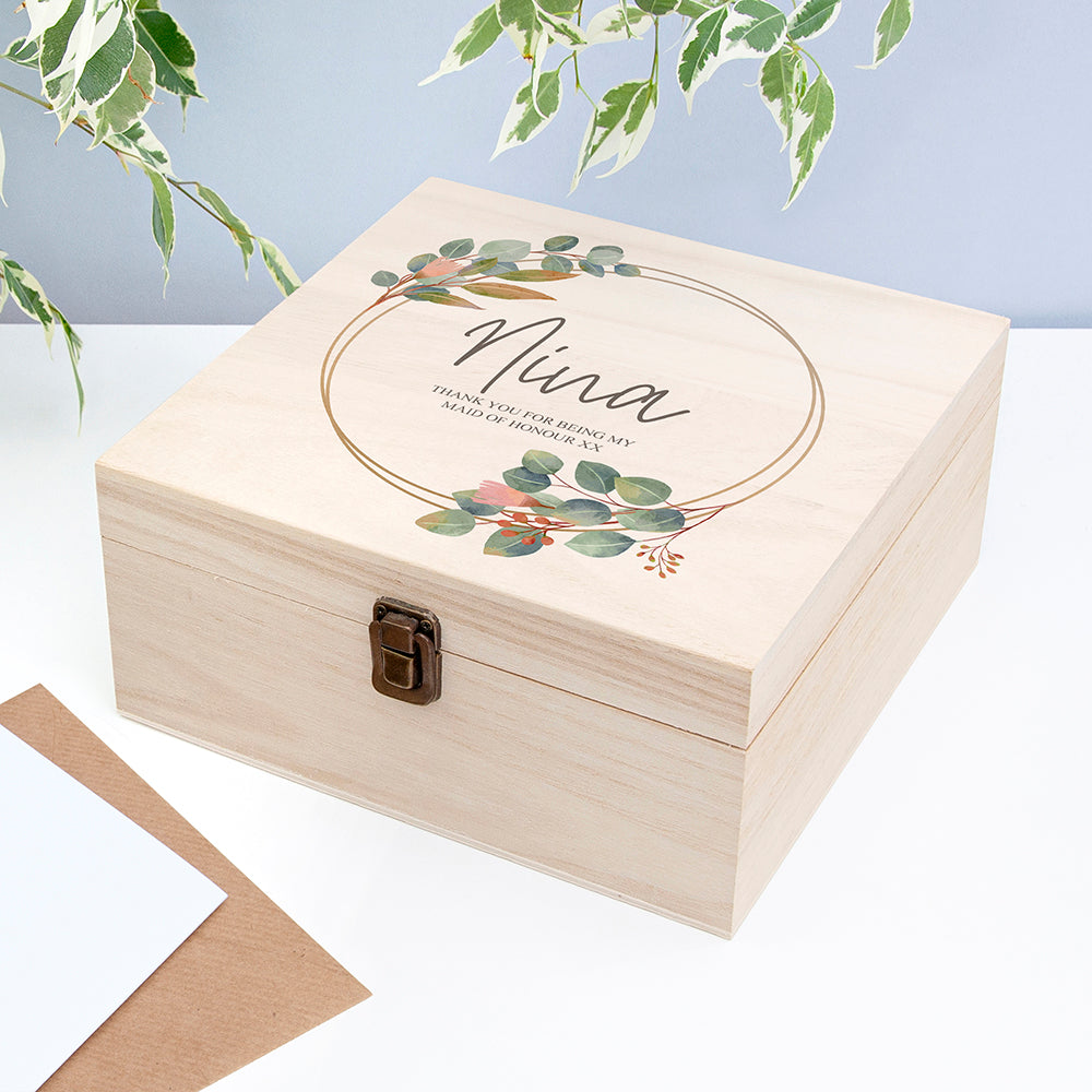 Wooden box with floral design and 'Nina' text on a light blue background